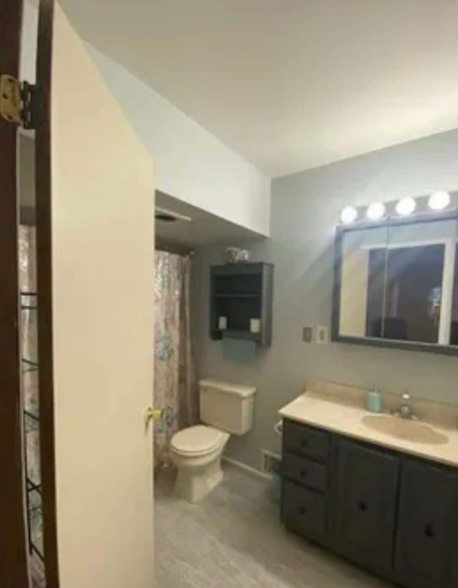 Dated bathroom with a dark vanity before the refit